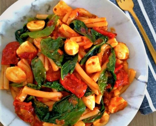 Macarrão caprese com muçarela, rúcula e tomate seco