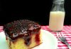 Poke cake de baunilha com geleia de frutas vermelhas e cobertura de chocolate amargo