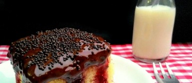 Poke cake de baunilha com geleia de frutas vermelhas e cobertura de chocolate amargo