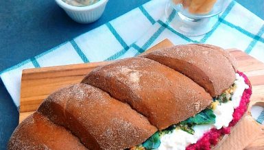 Sanduíche de pasta de beterraba com castanhas, queijo cremoso, pesto e rúcula