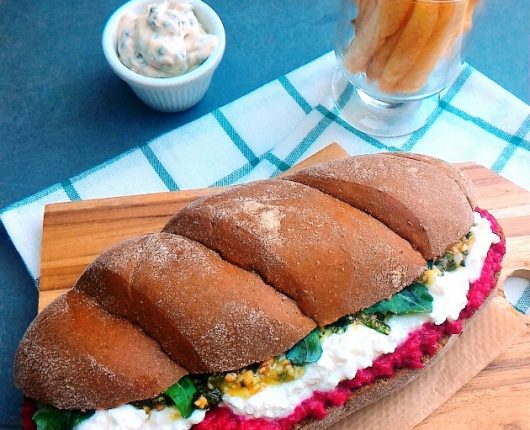 Sanduíche de pasta de beterraba com castanhas, queijo cremoso, pesto e rúcula