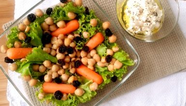 Salada com mini cenouras, grão de bico, uvas passas e coalhada seca temperada